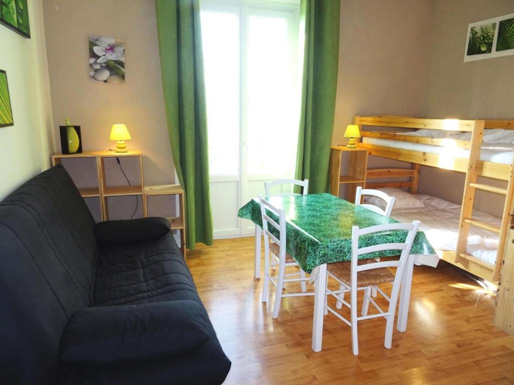 uma sala de estar com um sofá, uma mesa e cadeiras em Residence Albion - Studio pour 2 Personnes 564 em Aix-les-Bains