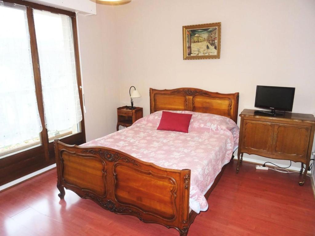 - une chambre avec un lit en bois et une télévision dans l'établissement Résidence Le Saint Charles B - Idéalement situé, à 50m de la Cure Thermale ! MAE-7874, à Aix-les-Bains