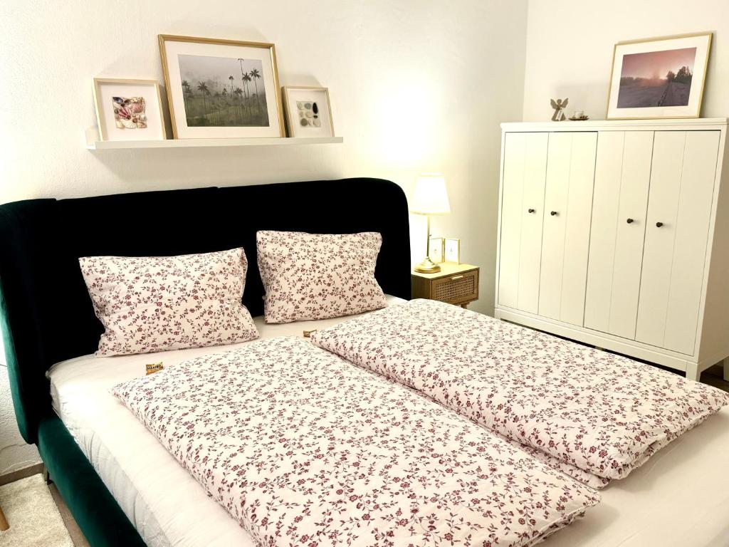アンベルク・イム・ランマータールにあるHelle Ferienwohnung Saunahausのベッドルーム1室(黒いヘッドボードと枕付きのベッド1台付)
