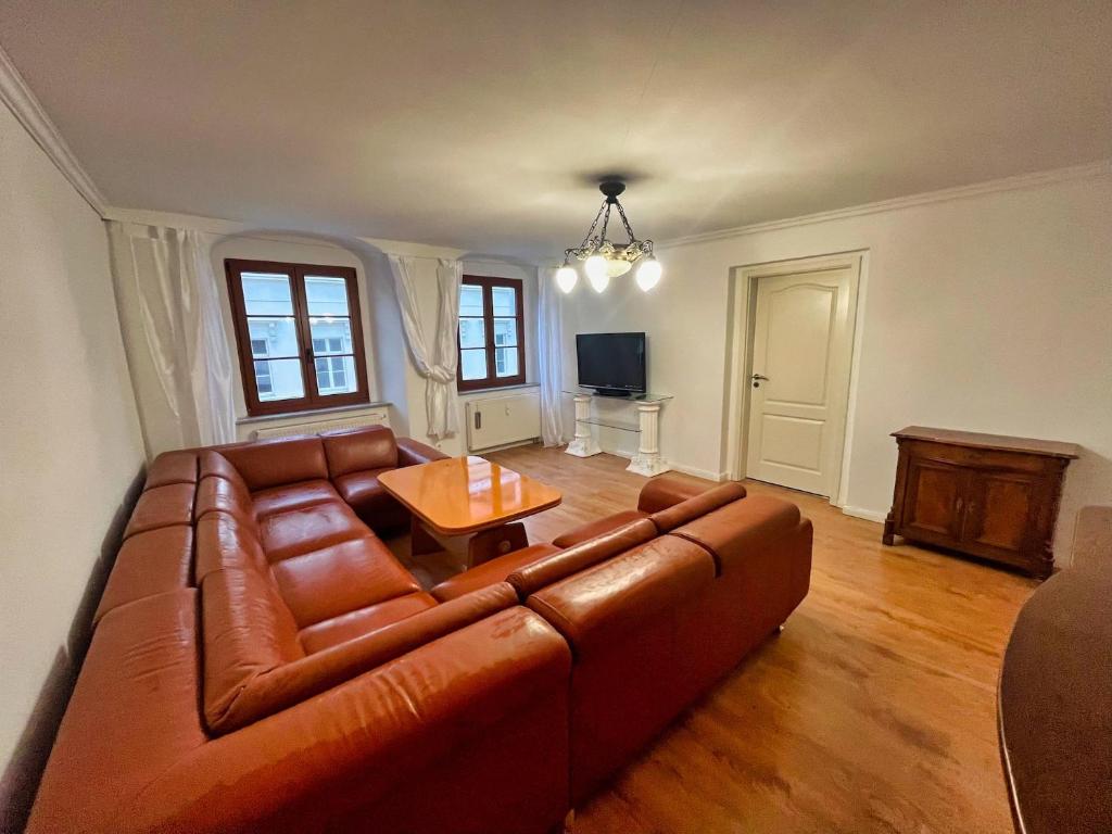 sala de estar con sofá de cuero marrón y mesa en großzügige Wohnung in der Altstadt mit Balkon, en Görlitz