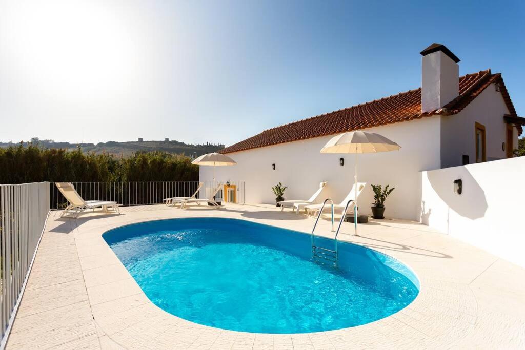 a swimming pool in front of a house at Casa da Azenha - Quinta do Boição - Private pool in Bucelas