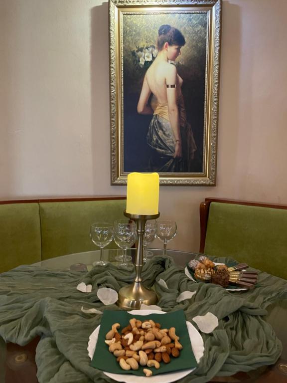 a table with a plate of food and a painting at Хотел Ботевград in Botevgrad