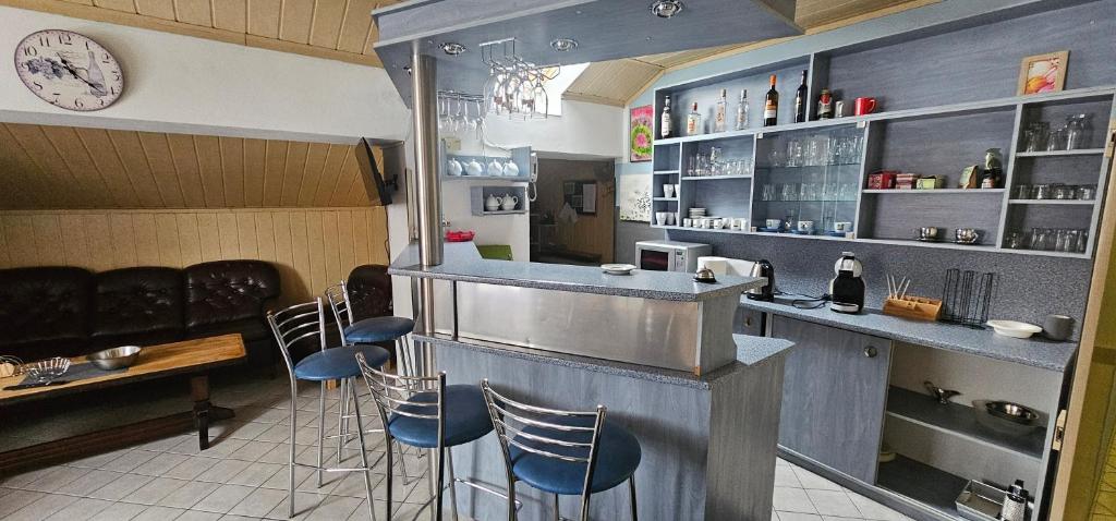 un bar con sgabelli in un ristorante con orologio di Ubytovanie u Vlka a Ľubotice