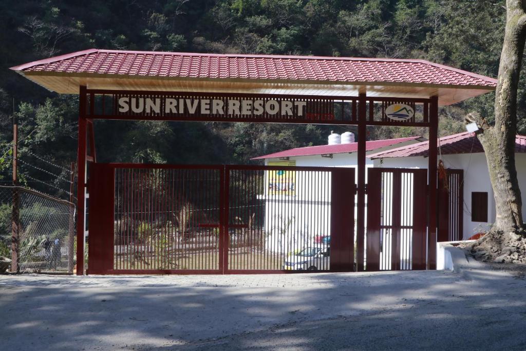 una puerta del resort del río soleado con un cartel en ella en Sun River Resort, en Dogadda