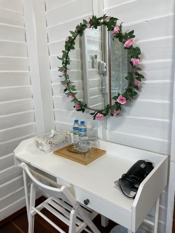a dressing table with a mirror and flowers on it at บ้านแสนรัก Casa Dolce Casa, Prakhon Chai in Prakhon Chai