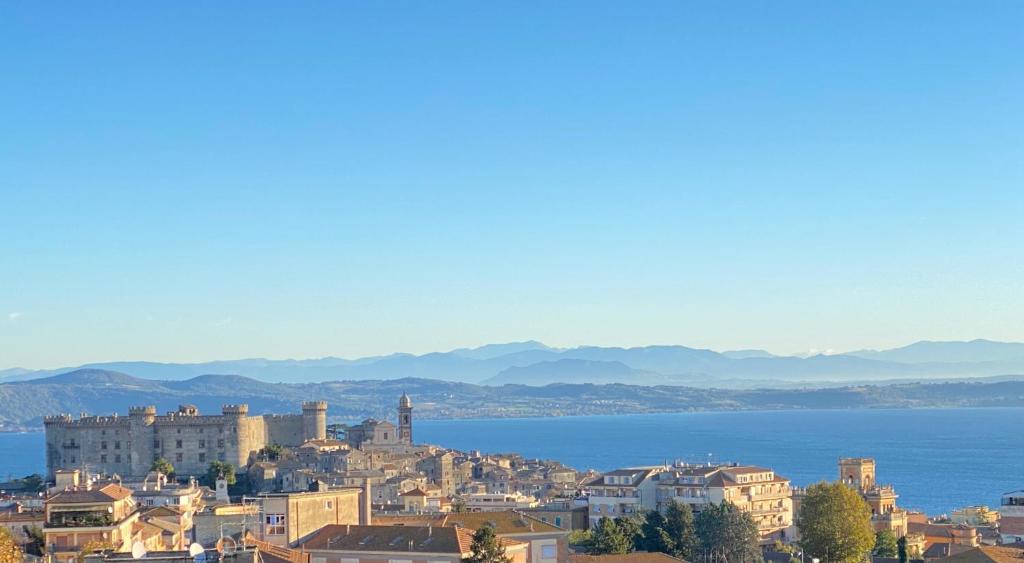 una città con vista sull'acqua e sugli edifici di Appartamento vista lago a Bracciano