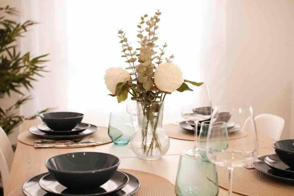a dining room table with a vase of flowers on it at Precioso apartamento a 10 min de la playa in Castellón de la Plana
