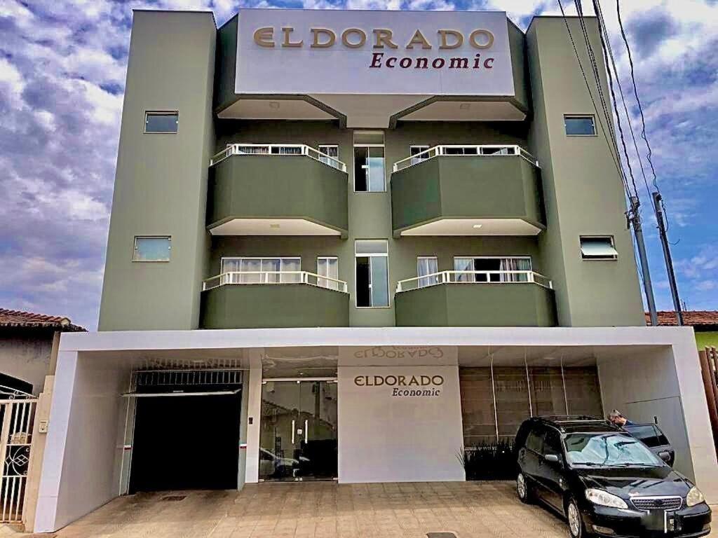 un bâtiment avec une voiture garée devant lui dans l'établissement HOTEL ELDORADO ECONOMIC, à Paracatu