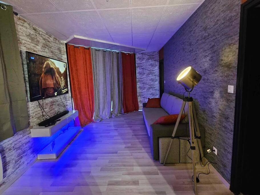 - un salon avec un canapé et une caméra dans l'établissement Cosy Loft - Calais, à Calais