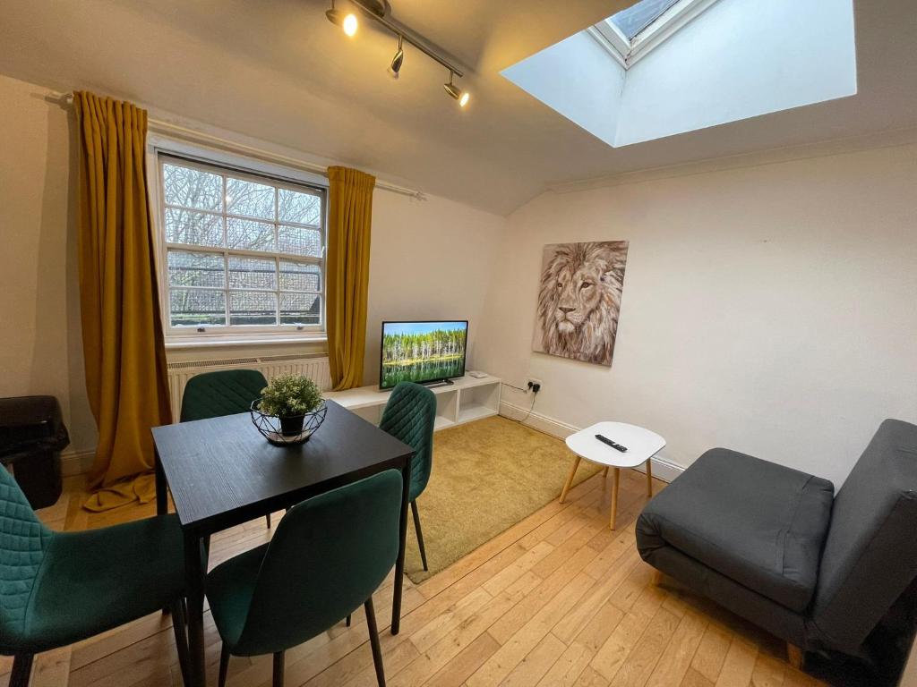 a living room with a table and chairs and a tv at The Islington Hub in London