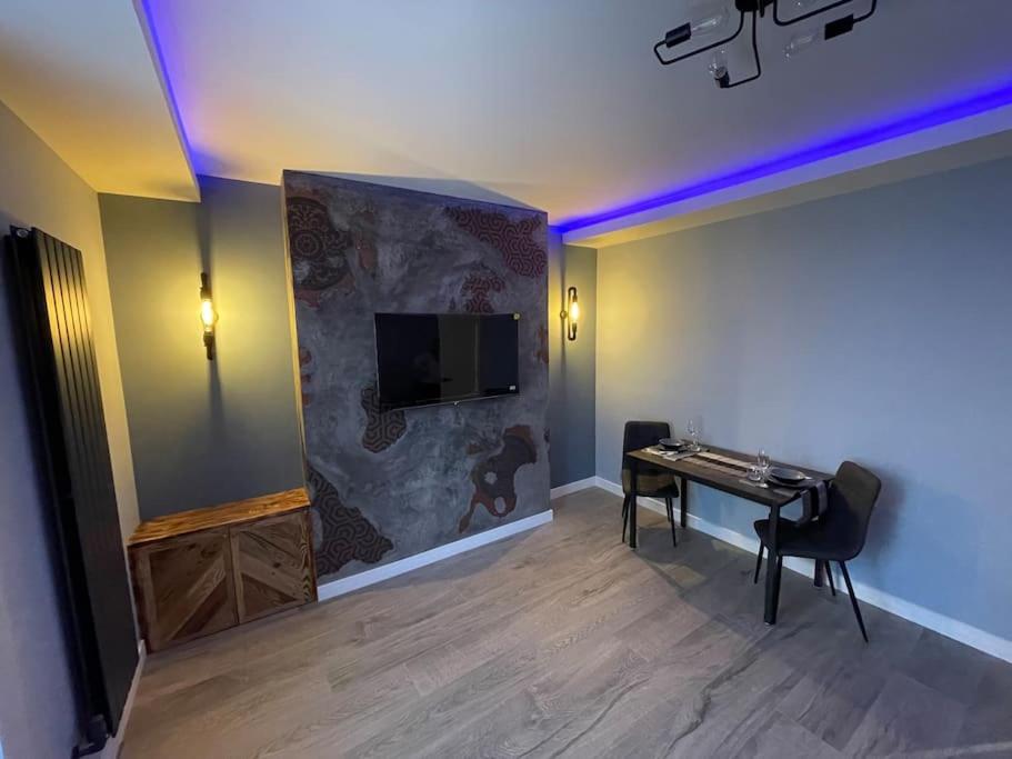 Pokój z biurkiem i telewizorem na ścianie w obiekcie 1bedroom ground floor apartment w Aberdeen
