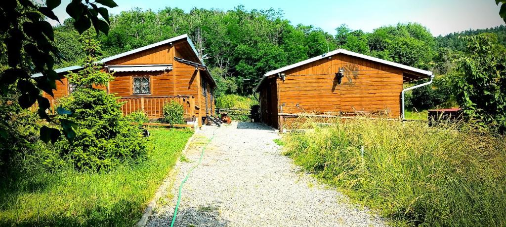 a couple of wooden buildings next to a dirt road at Ranč Skalka in Rousínov