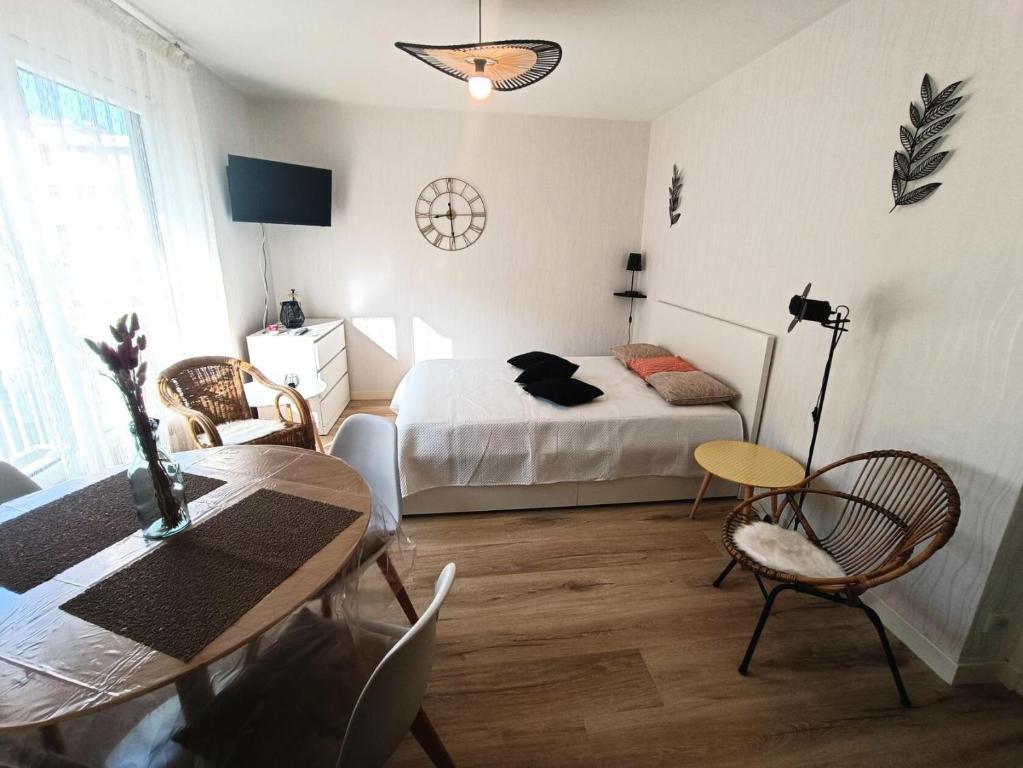 um quarto com uma cama, uma mesa e cadeiras em Résidence Montcalm C - Studio pour 2 Personnes 004 em Aix-les-Bains