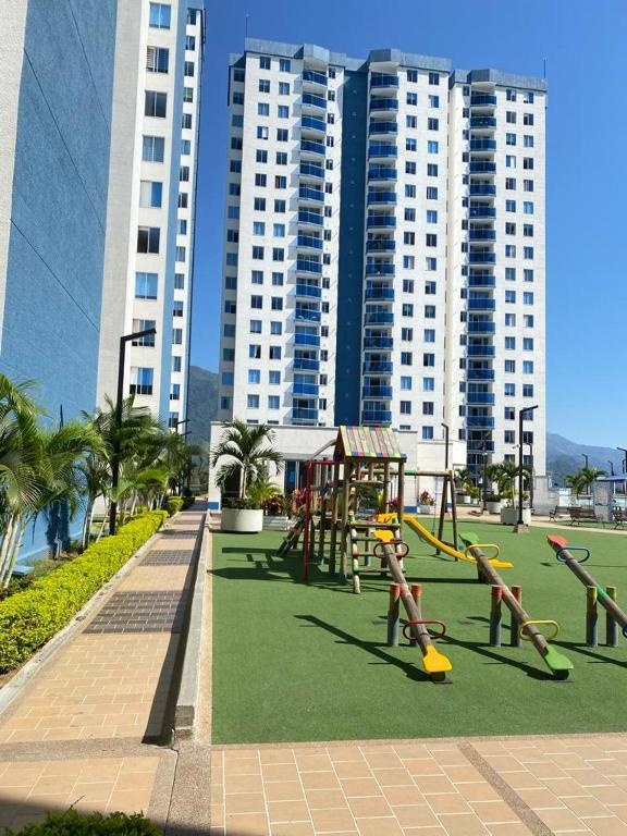 a playground with play equipment in a park with tall buildings at Apartamento en Ibagué - Varsovia in Ibagué