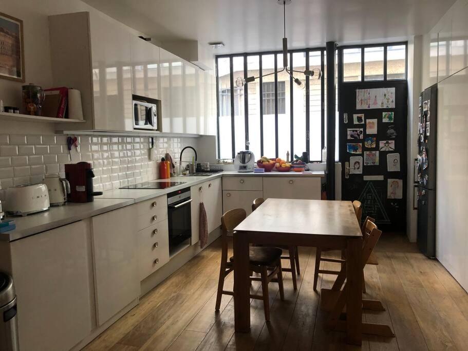 a kitchen with a table and a table and chairs at Loft 50m2 entre la Seine et le Panthéon in Paris