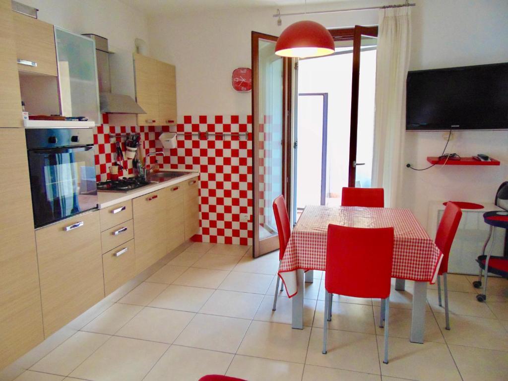 una cucina con tavolo e sedie rosse di SE043 - Senigallia, nuovo trilocale accessoriato a 100 mt dal mare a Senigallia