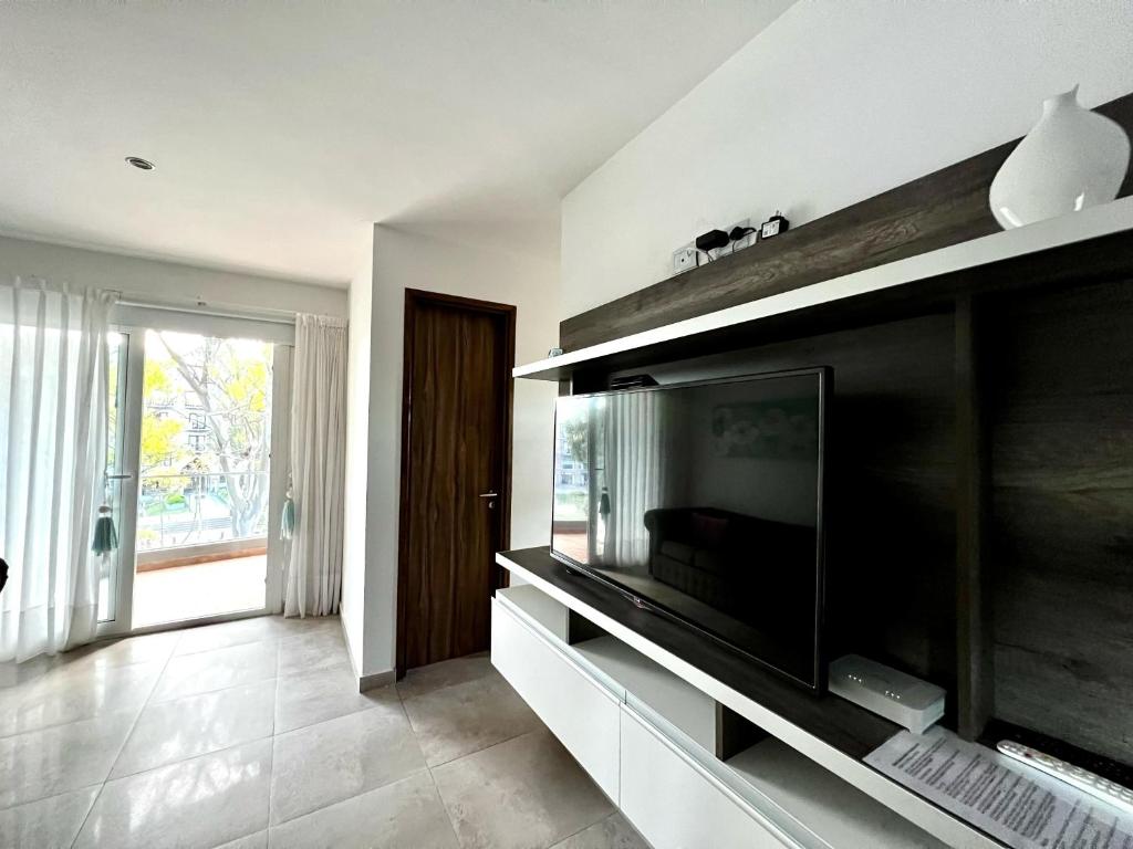 sala de estar con TV de pantalla plana en la pared en Departamento - Tres Ambientes - Avenida Bunge 1300 - Pinamar, Costa Atlántica - Renata 20 en Pinamar