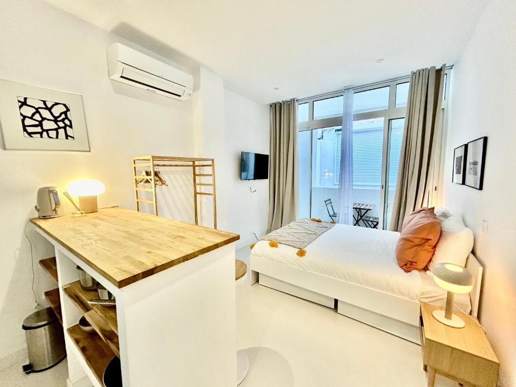 une chambre blanche avec un lit et une fenêtre dans l'établissement STUDIO AU CALME A CASTELLANE, à Marseille