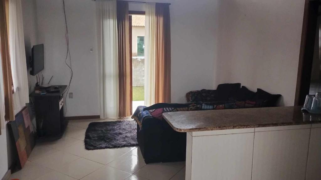 Il comprend un salon avec un canapé et une cuisine avec une fenêtre. dans l'établissement Sol e mar, à Iguaba Grande