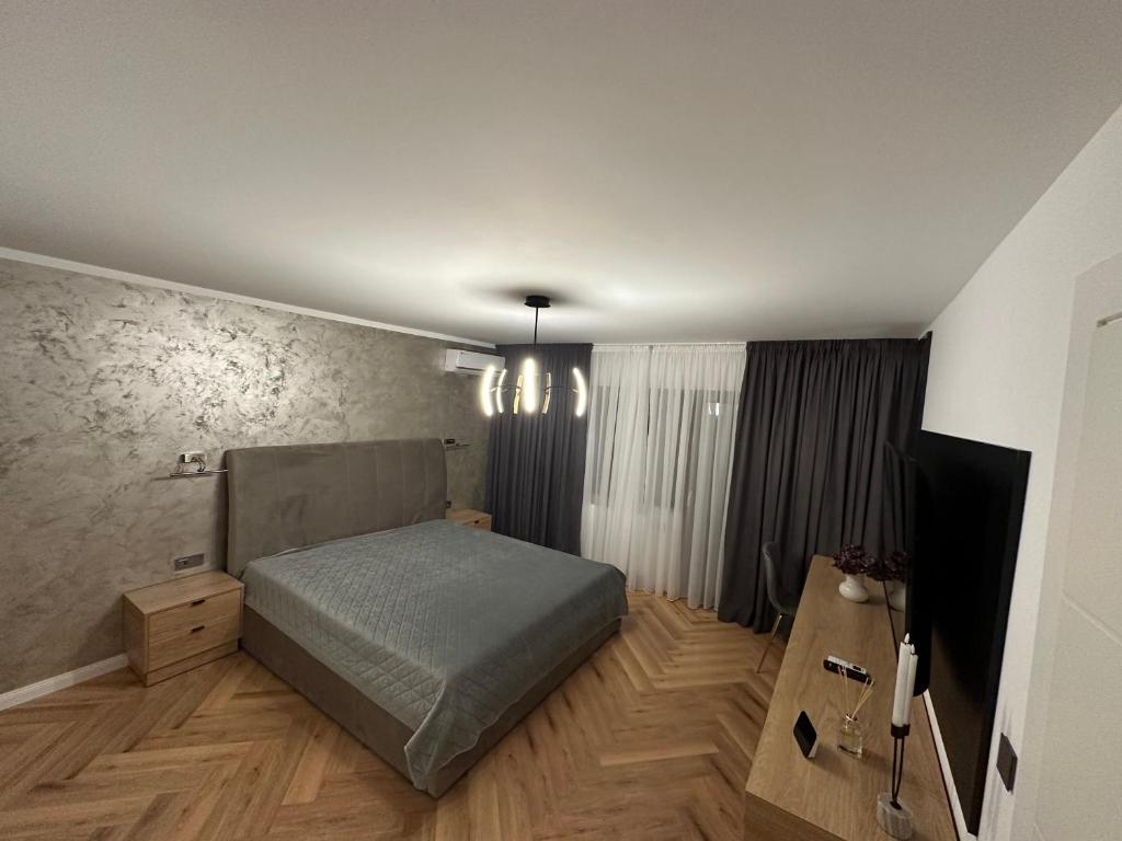 um quarto com uma cama e uma televisão em Traian Deluxe em Drobeta-Turnu Severin