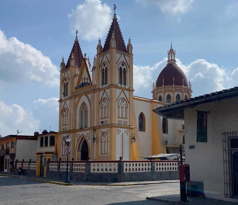 a large church with two towers on a street at Estudio en el centro de Coatepec in Coatepec