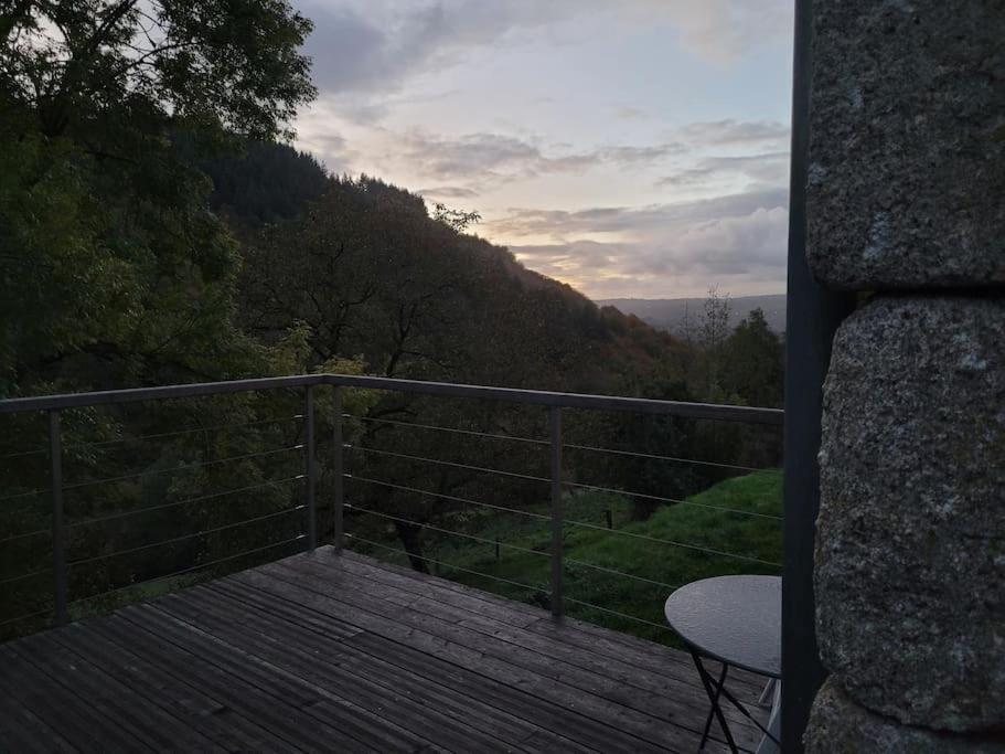 balcón con mesa y vistas a la montaña en L'Ostel Aveyronnais, en Golinhac