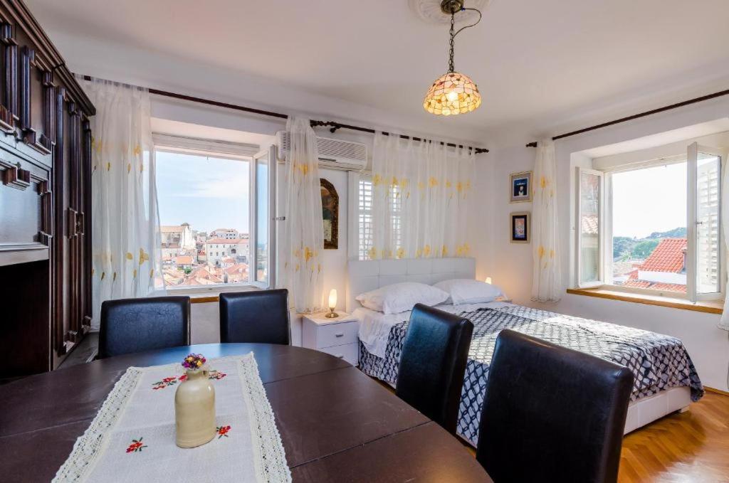 ein Schlafzimmer mit einem Bett und einem Tisch und Stühlen in der Unterkunft Apartment Ivona in Dubrovnik