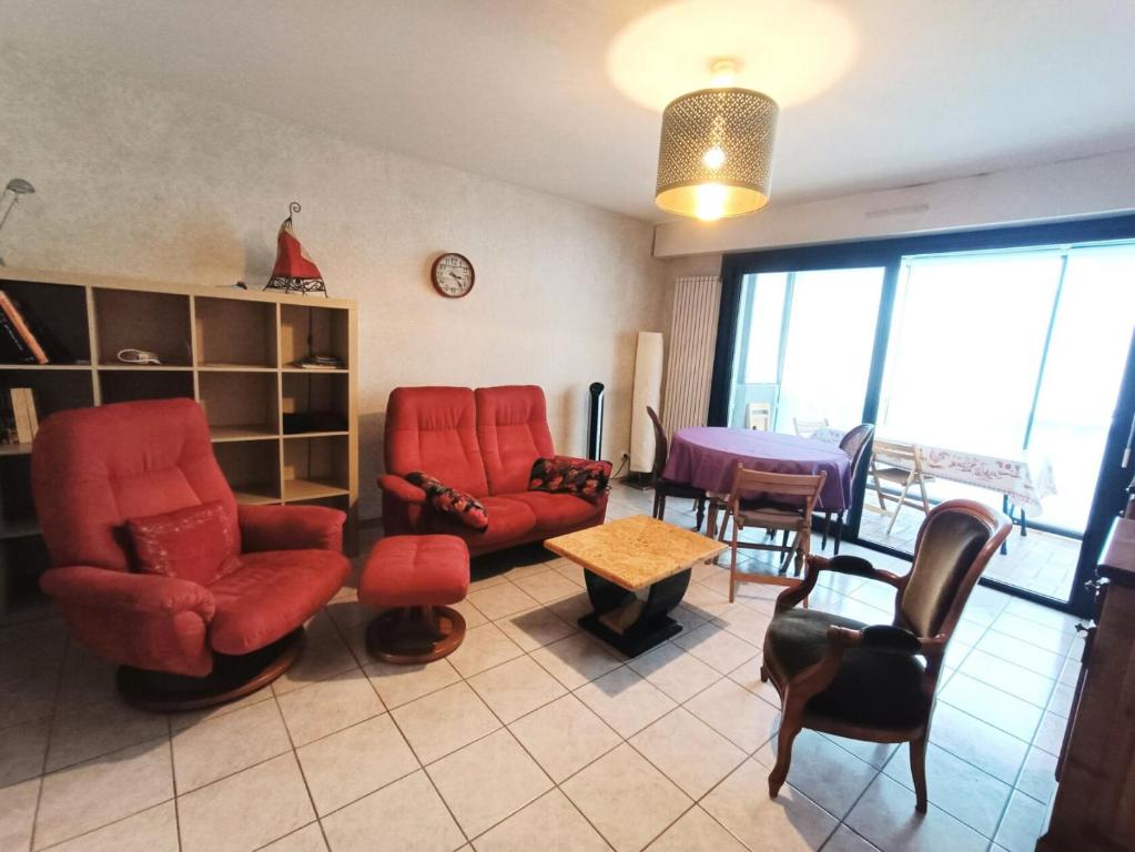 un salon avec des chaises rouges et une table dans l'établissement Résidence Les Guppys - Belle surface pour cet appartement et très central ! MAE-3354, à Aix-les-Bains