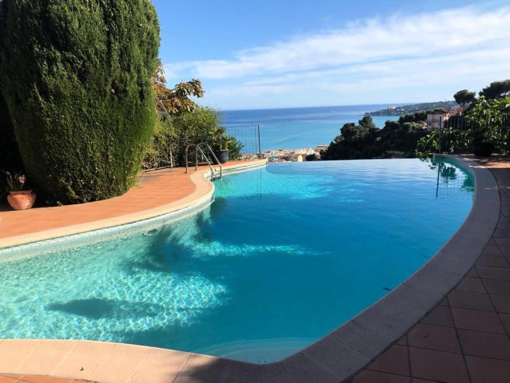 een groot zwembad met uitzicht op de oceaan bij Résidence Villa Rocca Maria - Maisons & Villas pour 8 Personnes 064 in Menton