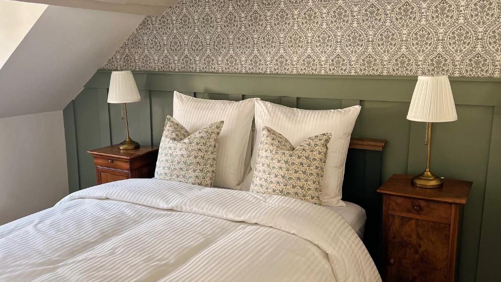 a bedroom with a bed with white sheets and pillows at The Brick House - Appartement Renoir in La Roche-Guyon