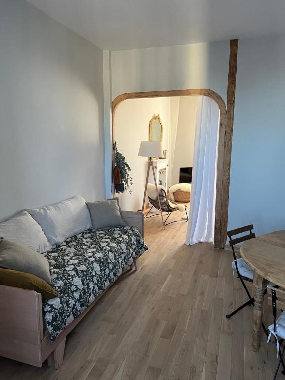 une chambre avec un lit, une table et un miroir dans l'établissement La Genette, à La Rochelle