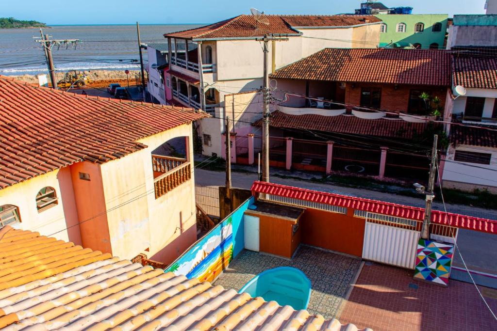 una vista aérea de los tejados de los edificios y del océano en Pousada Mirante do Sol en Piúma