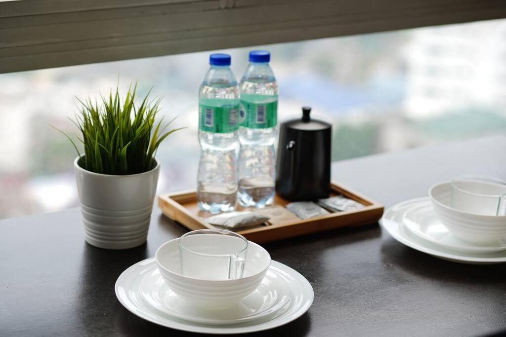 a table with plates and bottles of water and glasses at Home w/ City View - Pool + Fast Wifi 3016 in Manila