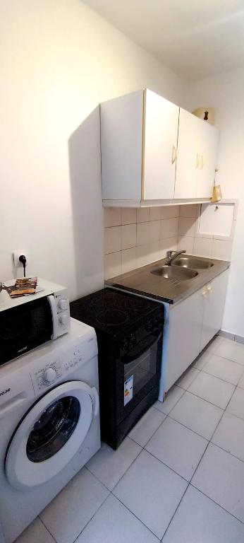 eine Küche mit einer Waschmaschine und einem Waschbecken in der Unterkunft Appartement 4 personnes Paris in Pontault-Combault