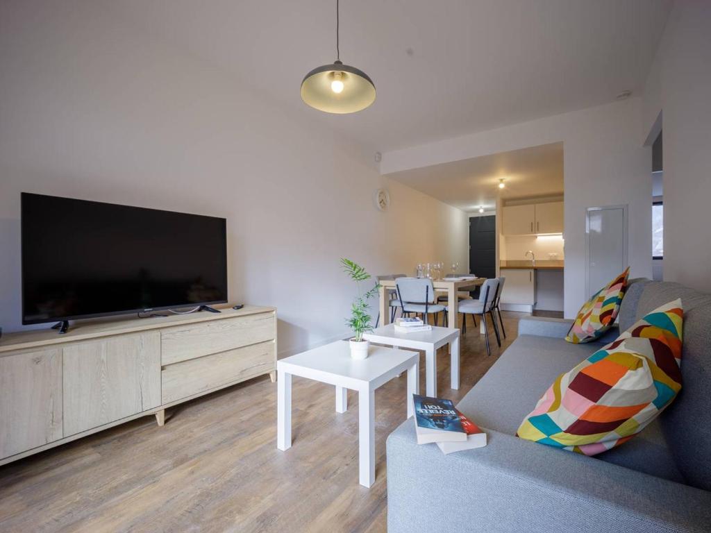 a living room with a couch and a tv at Appartement Loudenvielle, 3 pièces, 6 personnes - FR-1-695-17 in Loudenvielle
