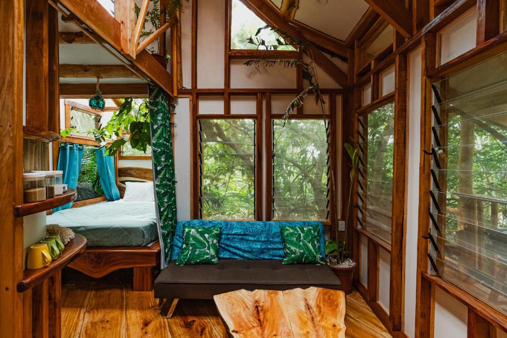 um quarto com uma cama e janelas numa casa na árvore em Tukulolo Treehouses em Makaunga