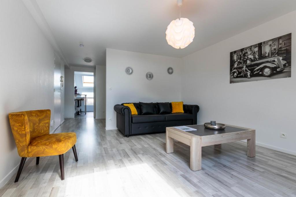 a living room with a couch and a table at bel appartement,confortable,2chambres in Briey