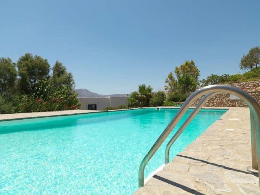 a blue swimming pool with a metal hand rail next to it at Villa Hermes - Luxury Villa Paros in Kampos Paros