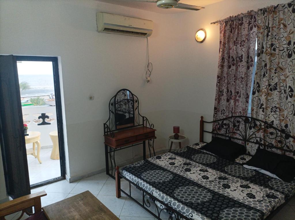 1 dormitorio con 1 cama y puerta que da a un patio en Brise de Mer Azur, en Yibuti