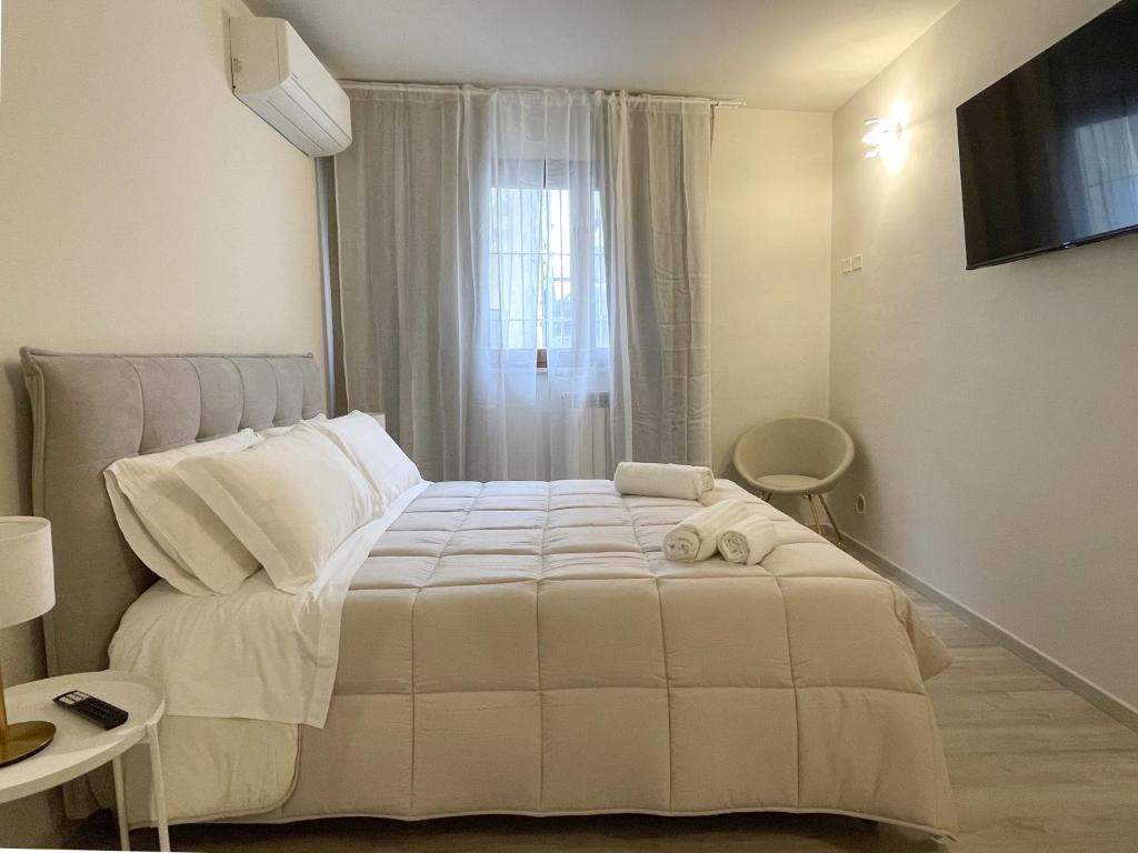 7Suites في إِمبولي: سرير أبيض في غرفة بها نافذة