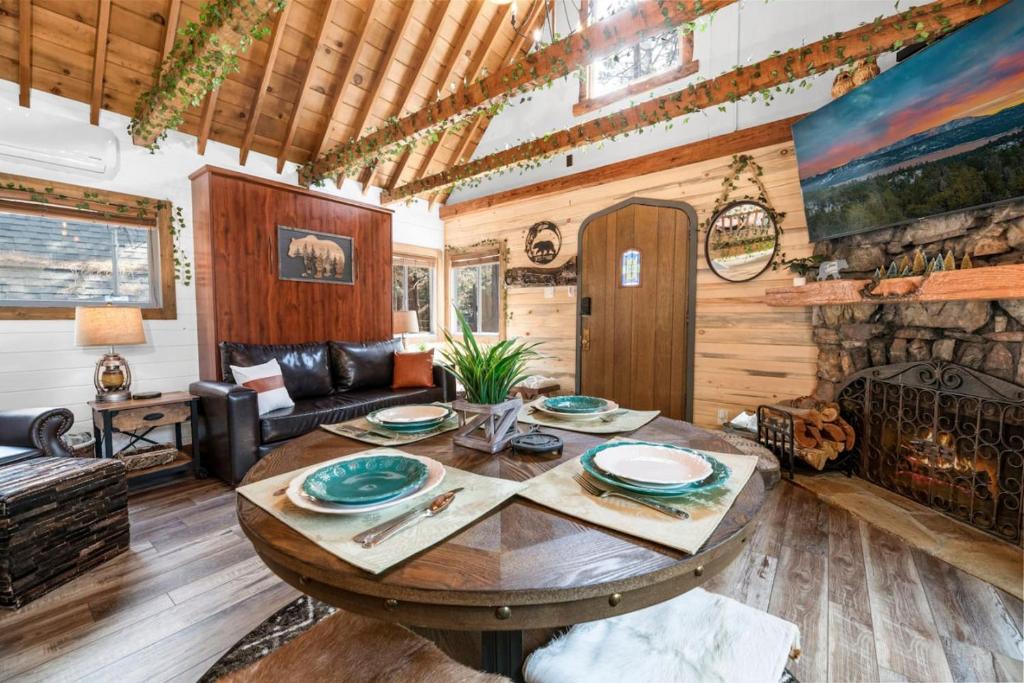 uma sala de estar com uma mesa e uma lareira em Hansel and Gretel Cottage em Big Bear City