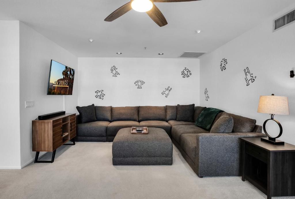 a living room with a couch and a ceiling fan at Keith Haring Inspired 2BD Deauville Condo - A Ryson Property in Palm Springs