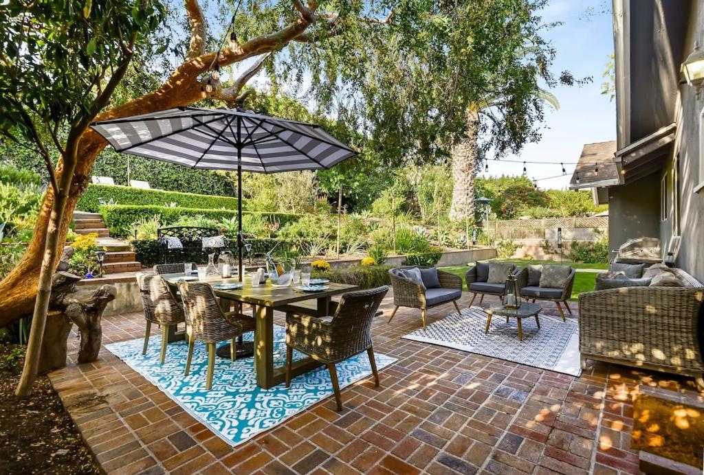 un patio con mesa, sillas y sombrilla en HAMPTON HOUSE PACIFIC PALISADES CA Ocean View Family & Pet Friendly Weekly & Monthly Discounts, en Los Ángeles