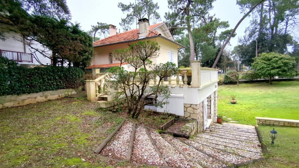 una pequeña casa con un árbol en el patio en Les Ecureuils Du Parc à 400 m de la plage, en Royan