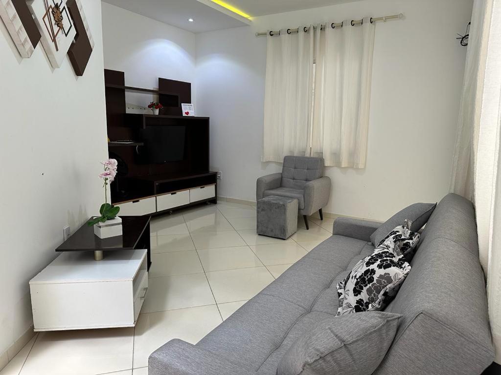 瓜賓的住宿－Casa Familiar - Guaibim，客厅配有灰色的沙发和电视