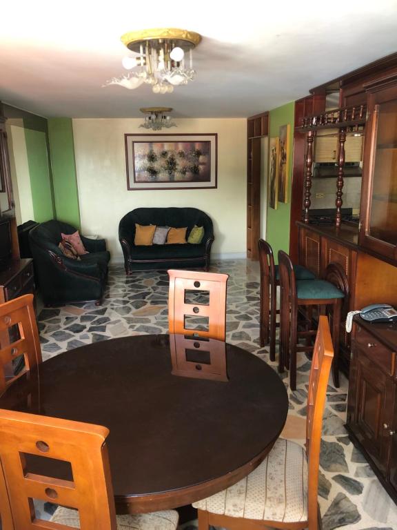 een woonkamer met een tafel en een bank bij Confortable Apartamento in Mérida