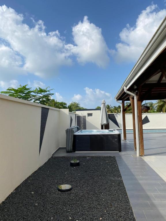 a patio with a white fence and a table at Villa marigua 2 in Les Abymes