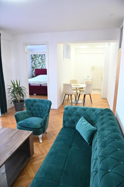 un soggiorno con divano verde e una camera da letto di Apartman Iva a Bijeljina