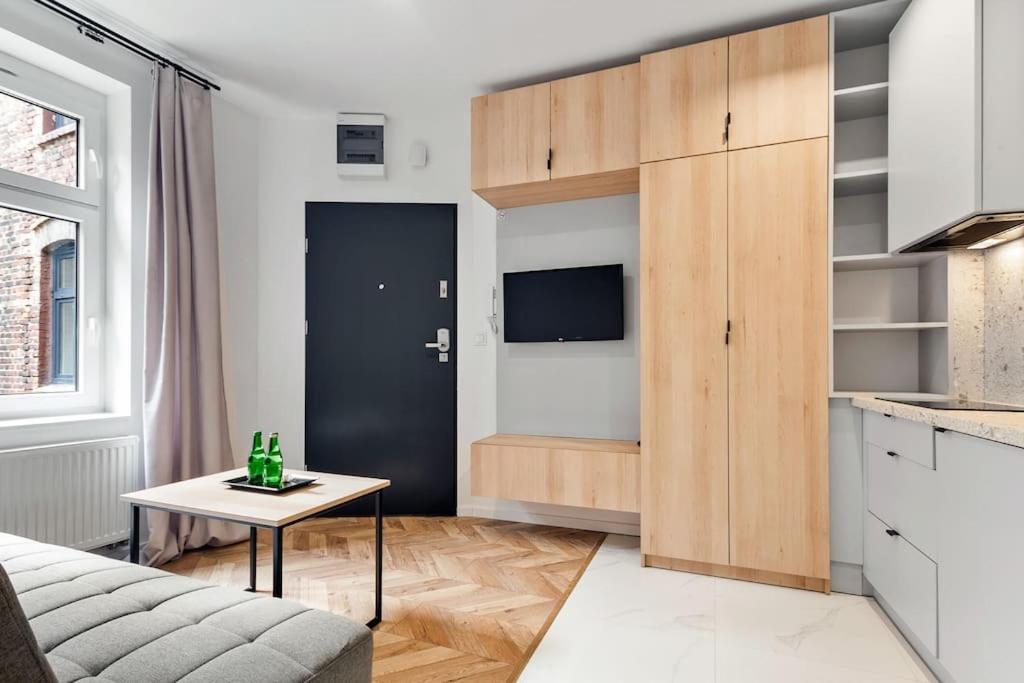 een woonkamer met een bank en een tafel bij Stylowy apartament z osobną sypialnią Powstańców4a in Katowice