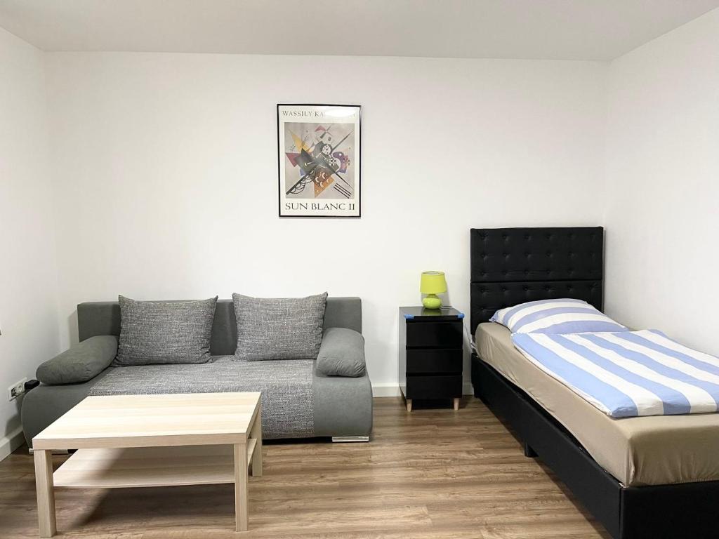 ein Wohnzimmer mit einem Bett und einem Sofa in der Unterkunft Easy to Düsseldorf Messe, 2-bedroom Apartment with kitchen and garden in Duisburg